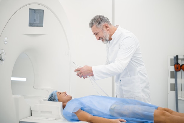 MRI Mężczyzna specjalista doagnostyki przygotowujący pacjenta do MRI