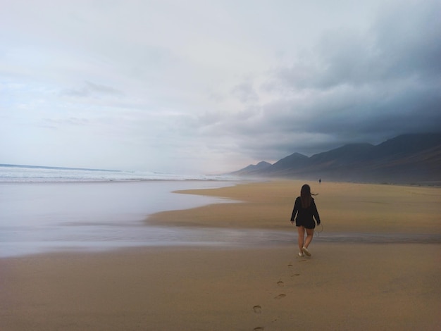 Mujer caminando por la playa en Fuerteventura