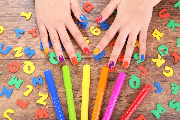 Multicolor żeński manicure z markierami na drewnianym tle