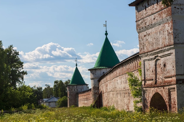 Mur Kremla to seria starych kamiennych murów z zielonymi dachami.