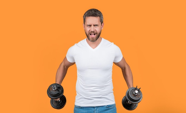 Muskularny facet fitness trenujący z ciężką sztangą w studio muskularny facet fitness trzyma sztangę