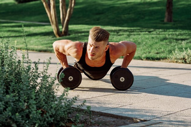Zdjęcie muskularny mężczyzna ćwiczy w parku.