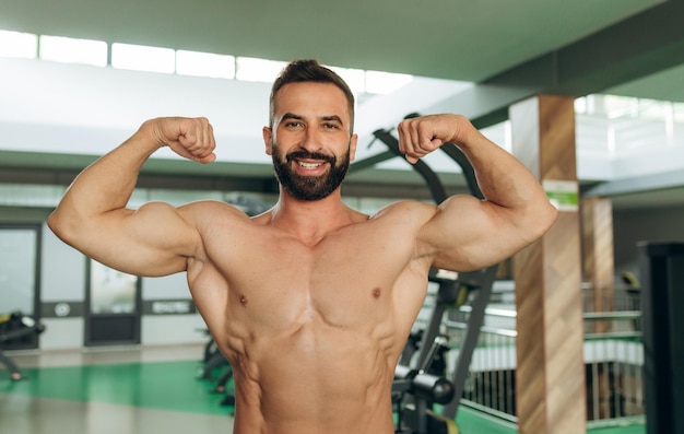 Muskularny mężczyzna na siłowni Mężczyźni fitness z nagim torsem pokazują bicepsy