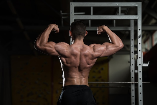 Muskularny mężczyzna napina mięśnie Pozycja tylnego podwójnego bicepsa