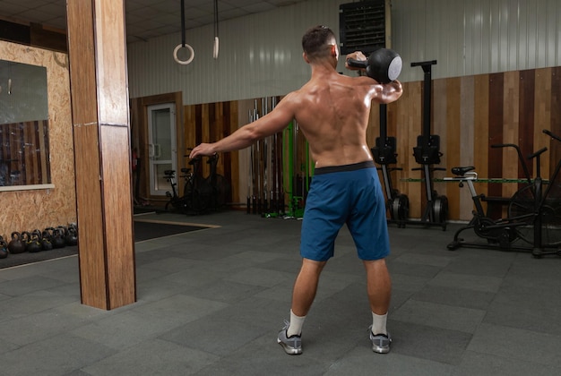 Muskularny Potężny Mężczyzna ćwiczenia Z Ciężkim Kettlebell W Siłowni Cross Fit. Trening Funkcjonalny Z Wolnymi Ciężarami