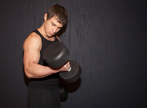 Muskularny Sportowiec Robi ćwiczenia Bicepsów Z Ciężkimi Hantlami Na Czarny Studio