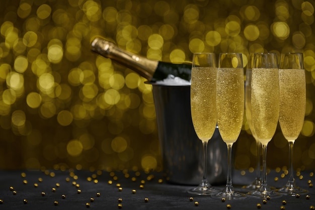 Musujące tło nowego roku. Butelka szampana z grzanką z kieliszków. Koncepcja uroczystości i święta.