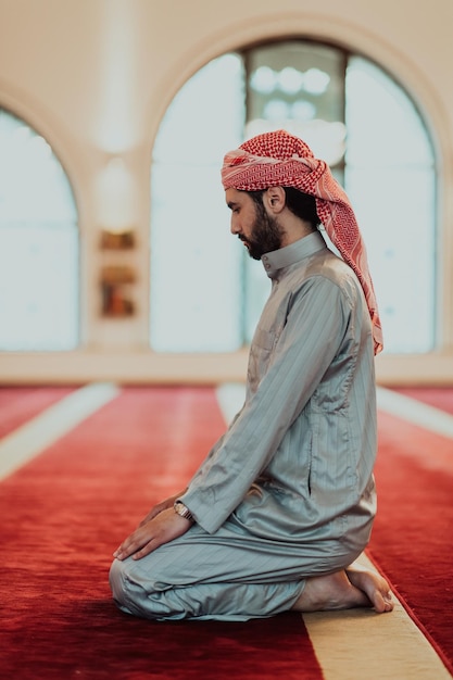 Muzułmanin modlący się w nowoczesnym meczecie podczas świętego muzułmańskiego miesiąca Ramadan.
