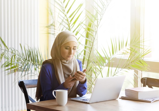 Muzułmanka azjatycka kobieta pracująca w biurze z laptopem