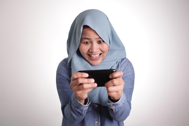 Muzułmanka podekscytowana graniem w gry na telefonie