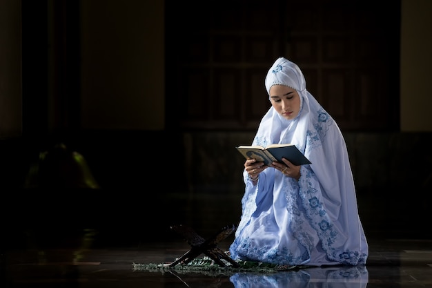 Zdjęcie muzułmanki w białych koszulach modlitwa zgodnie z zasadami islamu.