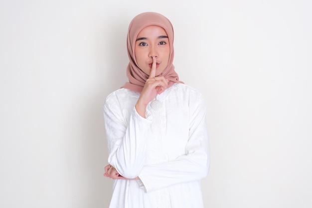 Muzułmańska Azjatka położyła palec na ustach, pokazując znak milczenia.