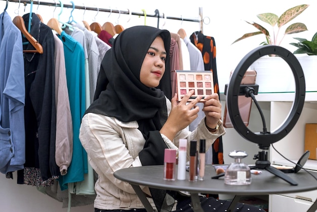 Muzułmańska azjatycka piękność influencerka w mediach społecznościowych transmisja na żywo marketing kosmetyków samouczek makijażu