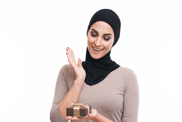 muzułmańska kobieta trzymająca prezent na białym