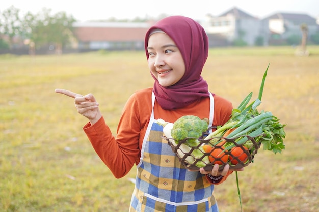 Muzułmańska kobieta trzymająca warzywa, wskazując coś