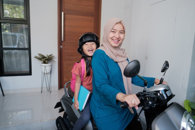 Muzułmańska matka zabiera córkę do szkoły motocyklem rano