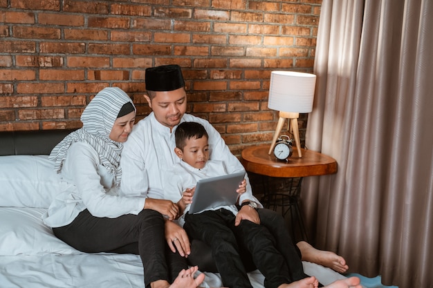 Muzułmańska Rodzina Używa Pastylkę Na łóżku