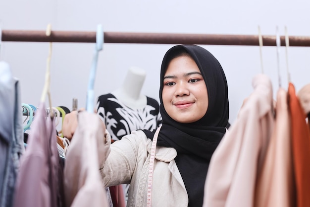 Muzułmańska sprzedawczyni sprawdza zapasy ubrań w sklepie i zapisuje dane w zeszycie