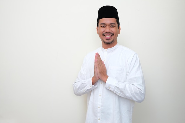 Muzułmański Azjata uśmiecha się przyjaźnie, gdy robi powitanie