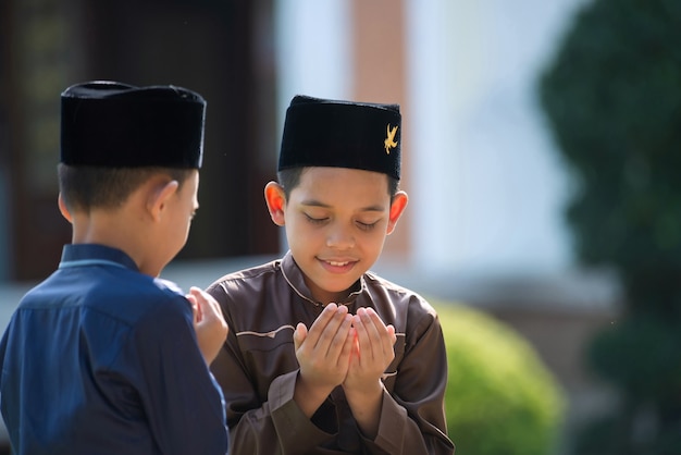 Zdjęcie muzułmańskie dziecko modli się, aby studiować z siostrą i bratem w meczecie w songkhla w tajlandii.