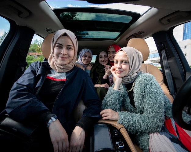 Muzułmańskie przyjaciółki cieszące się wycieczką samochodową podróżującą na wakacjach w samochodzie. Wysokiej jakości zdjęcie