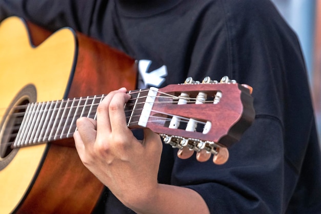 Muzyk uliczny gra na gitarze Zbliżenie dłoni wyrywających akordy Gryf gitary