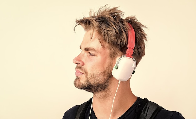 Muzyka duszy nieogolony mężczyzna słucha muzyki w zestawie słuchawkowym seksowny muskularny mężczyzna słucha muzyki sportowej mężczyzna w słuchawkach na białym tle