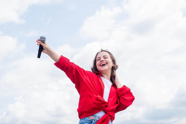 Muzyka i życie. teen dziewczyna śpiewa piosenkę z mikrofonem. mieć imprezę. Szczęśliwy dzieciak z mikrofonem. Śpiewanie piosenek w karaoke. Koncepcja życia i ludzi. spraw, aby twój głos był głośniejszy.