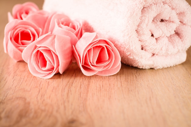 Zdjęcie mydło w postaci kwiatów i ręcznika na drewnianym tle
