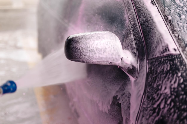 myjnia samoobsługowa myjnia samochodowa różowa pianka spływa po karoserii