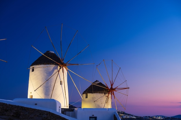 Mykonos Grecja Tradycyjne wiatraki Symbol Mykonos podczas zachodu słońca Krajobraz podczas zachodu słońca Brzeg morza i plaża Zdjęcie do podróży i wakacji