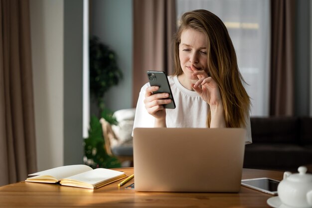 Myśląc o nauce online kobieta z okularami używa aplikacji telefonicznej i laptopa