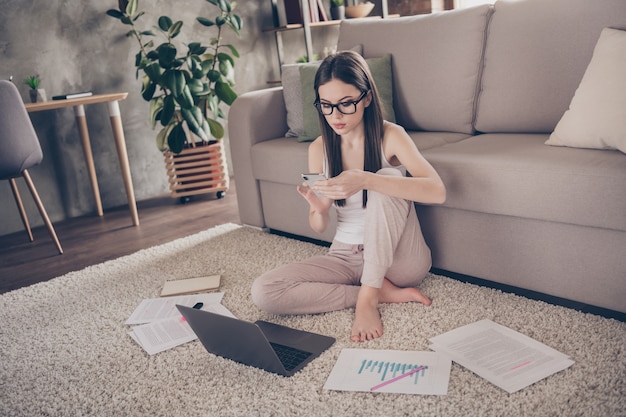 myśląca inteligentna dziewczyna korzysta z komunikacji online smartfona