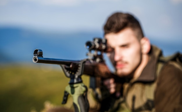 Myśliwy z bronią myśliwską i formą myśliwską do polowania Myśliwy celuje Mężczyzna jest na polowaniu Myśliwski karabin myśliwski Człowiek myśliwy Obserwacja strzelca w celu Okres polowania Samiec z bronią Zbliżenie