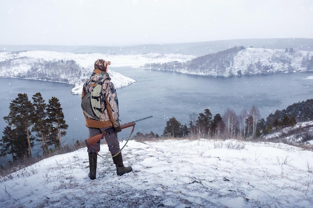 Myśliwy z karabinem podczas polowania zimowego Koncepcja stylu życia aktywności męskiej hobby