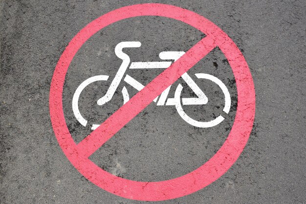 Na asfalcie znak drogowy zakazujący poruszania się rowerzystom