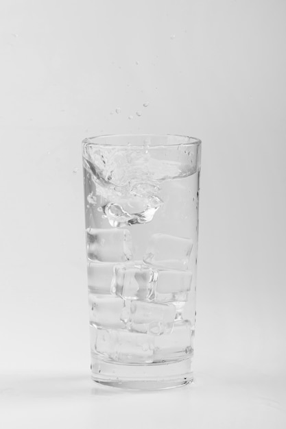 Na białym tle szklanka wody z cieniami