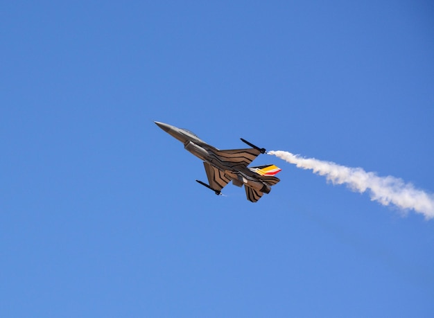 Na błękitnym niebie leci wojskowy myśliwiec