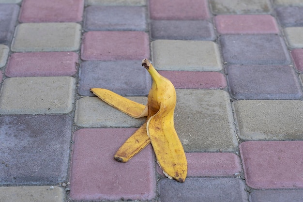 Na chodniku pozostawiono skórkę od banana Niebezpieczeństwo może się ześlizgnąć Jeśli ktoś po niej chodzi Uważaj na śliską Zbliżenie na zewnątrz