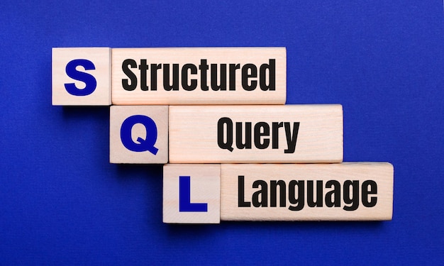 Zdjęcie na jasnoniebieskim tle jasne drewniane klocki i kostki z tekstem sql structured query language