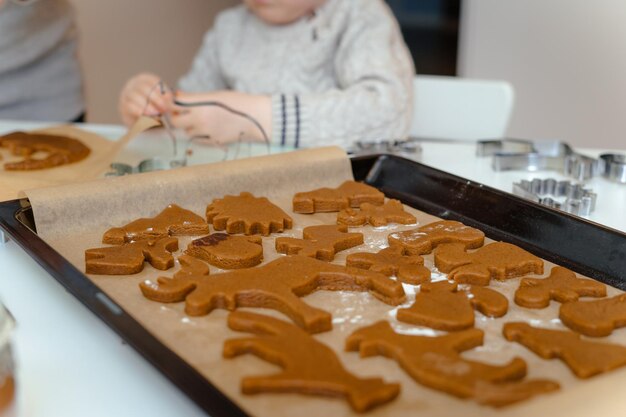 Na pierwszym planie blachy do pieczenia ze świątecznymi piernikami w kształcie zwierzątek