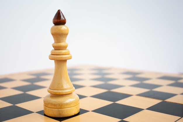 Na pierwszym planie szachownicy biały król jest w zbliżeniu.