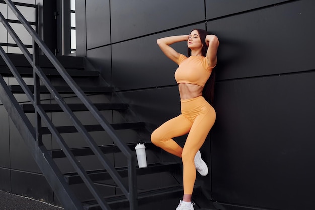 Na schodach z butelką wody Młoda kobieta w stroju sportowym ma sesję fitness na świeżym powietrzu