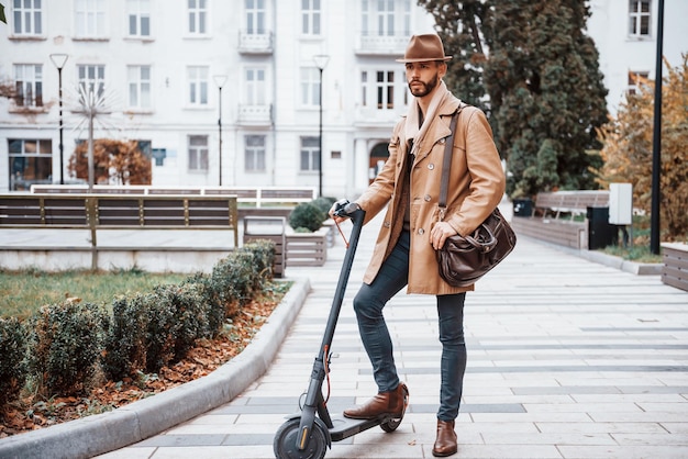 Na Skuterze Elektrycznym Młody Model Mężczyzny W Modnych Ubraniach Jest Na Zewnątrz W Mieście W Ciągu Dnia