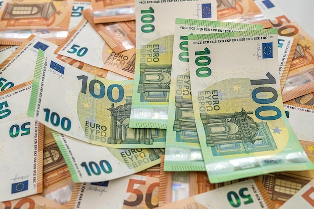 Na Stole Porozrzucane Są Nowe Banknoty 50 Euro, A Na Nich Leżą Banknoty 100 Euro Acuranto