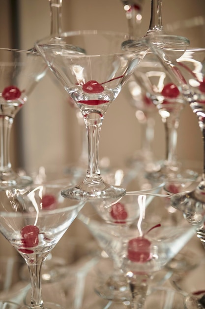 Zdjęcie na stole wieża pustych kieliszków do martini z wisienką