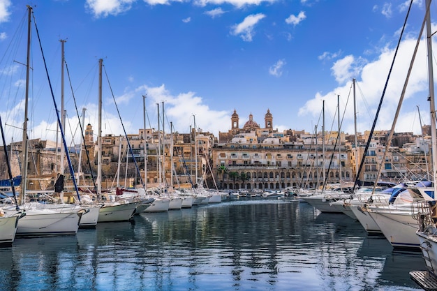 Nabrzeże Senglea Malta z zacumowanymi łodziami rekreacyjnymi i tradycyjnymi budynkami z wapienia