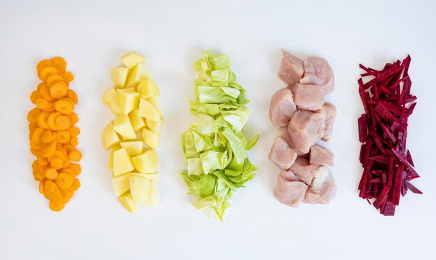 Zdjęcie nacięte kolorowe warzywa i mięso na białym tle koncepcja gotowania