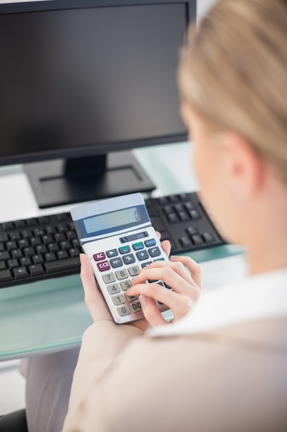 Nad naramiennym widokiem bizneswoman używa kalkulatora