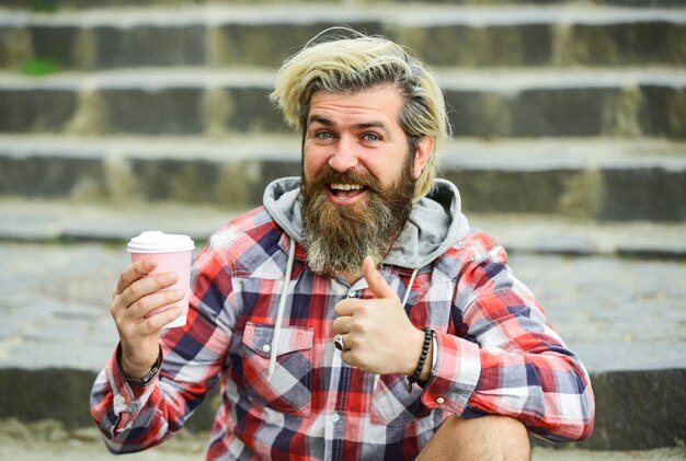 Najwyższej jakości brodaty hipster facet ubrany na co dzień lubi relaksować się w weekendowy poranek napoje koncepcja student na przerwę na kawę brodaty mężczyzna pije kawę siedząc na zewnątrz